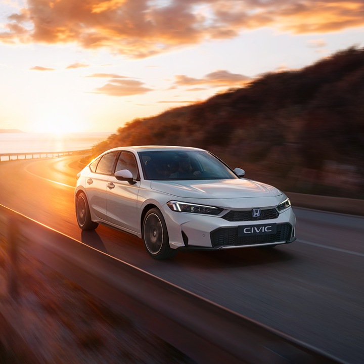 Nowa Honda Civic e:HEV jadąca na drodze, widoczna od boku