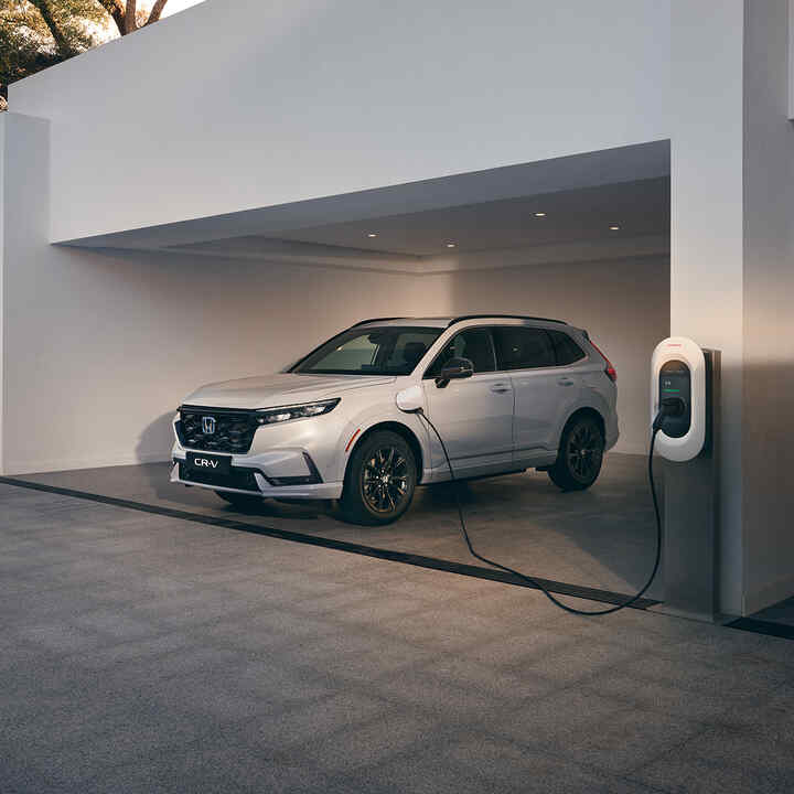 Honda CR-V e:PHEV Plug-In zaparkowana pod zadaszeniem, z podłączoną ładowarką
