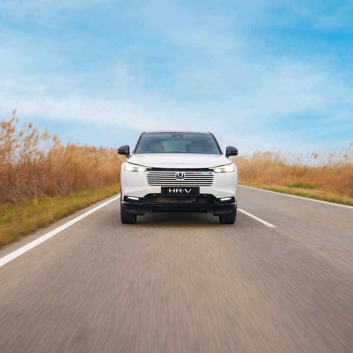 Nowa Honda Civic e:HEV jadąca na drodze, widoczna od boku